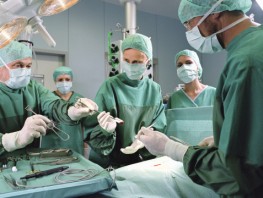 Operating room scene of doctors operating on person who has suffered internal organ damage and bleeding.